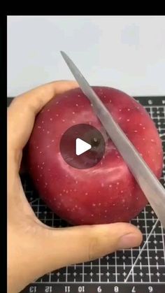 someone is cutting an apple with a knife