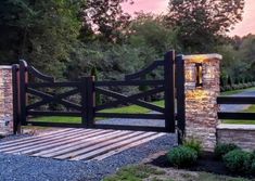 a stone and wood gate with brick pillars