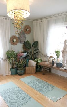 a living room filled with lots of plants next to a chandelier and window