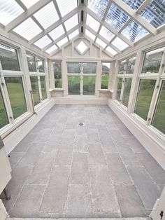 an empty room with large windows and tiled floor