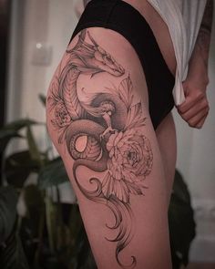 a woman's thigh with a snake and flowers on it