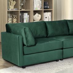 a green couch sitting in front of a book shelf