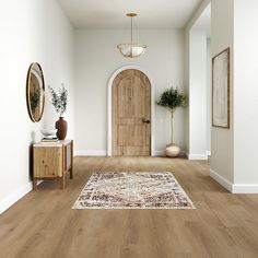 a hallway with wood flooring and an area rug in front of a wooden door