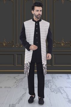 Introducing our R14-S76 Sherwani, a modern and elegant addition to your wardrobe. The unique floral design on the open jacket sherwani exudes sophistication and style. Elevate your look and make a statement with this premium piece. Designer Nehru Jacket With Chikankari Embroidery, Designer Nehru Jacket For Eid Reception, Designer Nehru Jacket With Cutdana In Traditional Drape, Nehru Jacket With Naqshi For Reception, Straight Kurta, Nehru Jacket With Naqshi For Reception, Elegant Nehru Jacket With Cutdana In Traditional Drape, Elegant Nehru Jacket With Cutdana Detailing, Elegant Nehru Jacket With Cutdana, Designer Bandhgala For Winter Reception