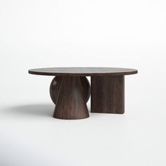 a wooden table sitting on top of a white floor next to a black object in the middle