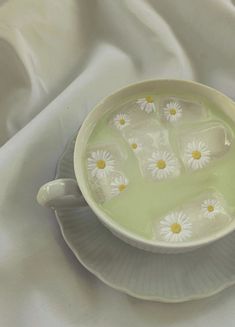 a white plate topped with lots of water and daisies on top of each other