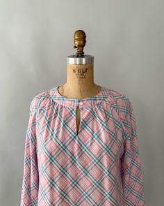 "An adorable spring blouse by Levi's from the late 1970s - early 1980s. Made from a pastel plaid cotton blend in shades of pale pink, blue and green, the blouse has a gathered neckline with a front button closure and keyhole, and long, puffy bishop sleeves that can also be rolled/cuffed and buttoned in place with the attached tab. Looks so cute tucked into high waisted jeans! Measurements Tag: Levi Strauss Material: 55% Cotton 45% Polyester Size: tagged a vintage size 10 and fits a modern small Gingham Blouse For Daywear, Vintage Plaid Spring Tops, Vintage Plaid Shirt For Spring, Vintage Plaid Top For Spring, Spring Plaid Cotton Blouse, Plaid Cotton Blouse For Spring, Cotton Plaid Blouse For Spring, Preppy Spring Blouse, Vintage Gingham Blouse For Spring