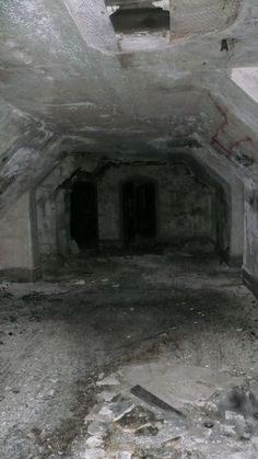 an old, run down tunnel with graffiti on the walls and cement floors that has been stripped off