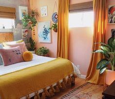 a bedroom with yellow drapes on the windowsills and a large bed covered in tassels