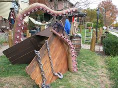 an octopus boat with chains attached to it's hull in the grass near a house