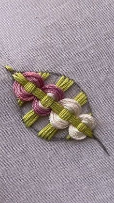 a close up of a piece of cloth with some knitting yarn on top of it