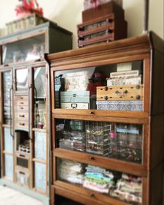 an old wooden cabinet filled with lots of boxes and other items on top of it