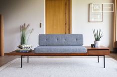 a couch sitting on top of a white rug in a living room next to a wooden table