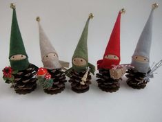 four little gnomes are sitting on pine cones