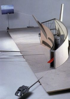 a computer mouse sitting on top of a white floor next to a building with a curved roof