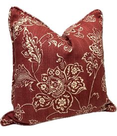 a red pillow with white flowers on the front and back, sitting on a white background