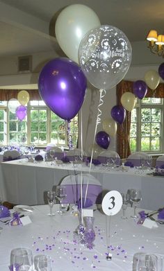 balloons and confetti are on the table at a wedding reception in purple and white