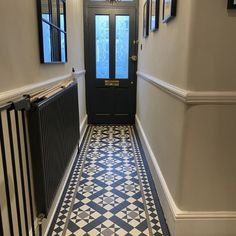 a hallway with black and white tile flooring and chandelier hanging from the ceiling