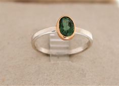 SOLD. This ring is available by special order only. Takes 1 week  if you use a stone I have in stock . I have stones in stock now oval , pear,square, square cushion cut.   Message me with your size and I will send pictures of the stones I have to choose from. .( The  sold stacking ring in the photos  has a 91ct oval green tourmaline ,which is set in an 18K gold bezel . The stone measures 7.5x5mm and weighs 1.8 grams. The sterling silver shank is 2mm in diameter. The ring weighs 1.8 grams total. Classic Oval Tourmaline Emerald Ring, Modern Oval Emerald Ring With Accent Stones, Modern Oval Tourmaline Rings, Green Tourmaline, Stacking Ring, Stackable Rings, Cushion Cut, Stacking Rings, Tourmaline