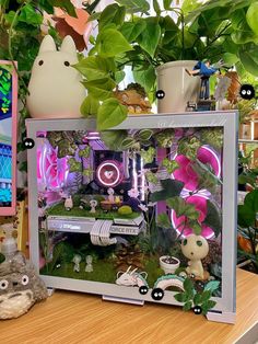 a display case filled with lots of plants next to a stuffed animal on a table