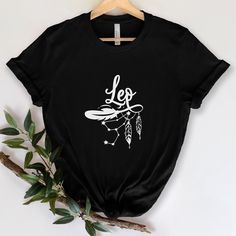 a black t - shirt with the words leo written on it and a white feather