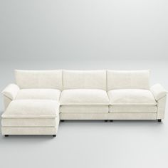 a white sectional couch sitting on top of a gray floor