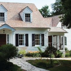 a white house with black shutters and windows