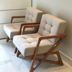 two chairs sitting next to each other in a room with white walls and marble flooring