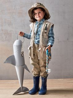 a little boy that is standing next to a toy shark with a hat and umbrella