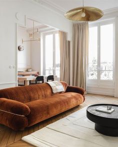 a living room filled with furniture and large windows