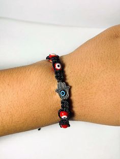 Carefully hand braided bracelet with charms that work as negativity shields. It is made with strong Black nylon thread and vibrant red evil eye beads ( represent courage and protection). The Hamsa hand is also a charm of protection and fortune caller as you can see it comes with a 2 mm evil eye in the middle (color blue, is the traditional color for good karma, positive energies, and protection against the evil eye.) When is finally made, the bracelet is then aligned with the wearer's name, an a Evil Eye Red Bracelet, Handmade Red Evil Eye Bracelet For Good Luck, Adjustable Red Bracelets With Evil Eye, Adjustable Black Hand-strung Evil Eye Bracelet, Adjustable Red Evil Eye Bracelet, Hand-strung, Kabbalah Bracelet, Hamsa Bracelet, Red Bracelets, Protection Bracelet