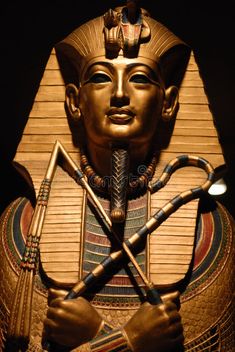 an egyptian pharaoh statue with two crossed spears in front of it's head and hands