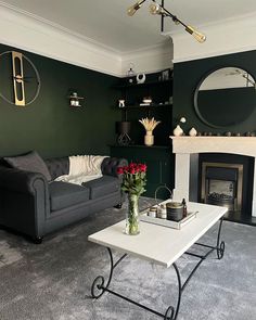 a living room filled with furniture and a fire place in front of a mirror on the wall