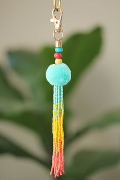 a close up of a keychain with beads and tassels on it