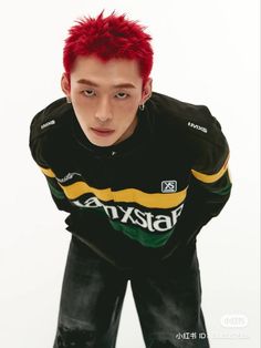 a young man with red hair is posing for the camera