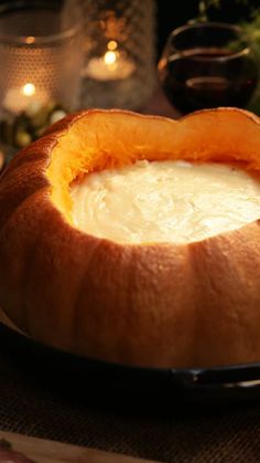 a bowl of soup sitting on top of a table next to candles and other food