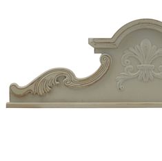 a white shelf with an ornate design on the top and bottom part, against a white background