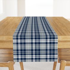 a plaid table runner on top of a wooden table