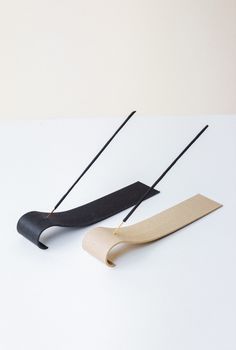 two black and white objects sitting on top of a table with sticks sticking out of them