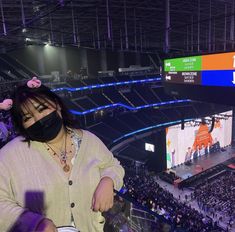 a woman wearing a face mask in front of an audience