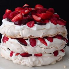 a cake with strawberries and cream on top is being held by someone's hand