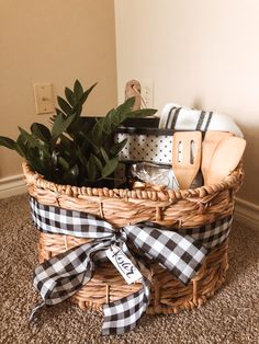 a basket filled with kitchen utensils on top of a carpeted floor next to a potted plant