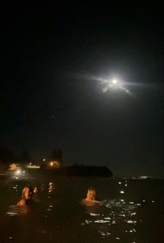 some people are swimming in the water at night