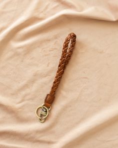 a braided leather keychain laying on top of a bed