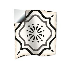 a black and white tile design on the side of a piece of paper with a sticker attached to it