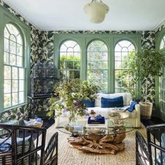 a living room filled with furniture and lots of green walls covered in wall coverings