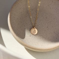 Our hand-stamped 3/8" Initial Disc Necklace adds a sweet personalized touch to your every day look. This mini monogrammed disc hangs from our favorite dainty chain. Hypoallergenic, water-proof and nickel free for long lasting everyday wear! Add a Tiny Birthstone Charm to make this necklace even more unique and gift-able. MEASUREMENTS Disc measures 3/8" in diameter Offered in 14", 16", 18", and 20"Available in 14k Gold Fill and Sterling SilverHypoallergenic, Nickel-Free, and Water Safe Small Personalized Charm Necklaces For Everyday, Personalized Small Charm Necklaces For Everyday, Dainty Hand Stamped Round Charm Necklace, Dainty Round Hand-stamped Charm Necklace, Dainty Hand-stamped Round Charm Necklace, Simple Round Pendant Charm Necklace For Everyday, Everyday Stamped Round Disc Charm Necklaces, Everyday Stamped Round Disc Charm Necklace, Dainty 14k Gold Round Disc Charm Necklace