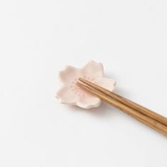 two chopsticks resting on top of a flower shaped dish