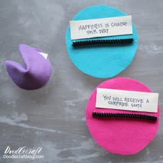 two pieces of felt with words on them sitting next to an egg shell and one piece of fabric