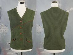 This stunning green vest has a delicate medallion tweed pattern on the upper-right front, lower-left front, and on the full back. The other part of the front is a fine boucle texture. The 1990s German vintage vest has two faux flap pockets on the front, and closes with four faux polished walnut seed buttons. The vest is lined in a green satin polyester fabric. Bust = 40 inches (101.6cm) Waist = 39 inches (99.06cm) Hips = 43 inches (109.22cm) Vest Length = 24 inches (60.96cm) Brand label: Meico L Winter Workwear Green Vest, Green Winter Workwear Vest, Green Winter Vest With Buttons, Classic Green Vest For Winter, Classic Green Winter Vest, Green Buttoned Vest For Workwear, Vintage Green Vest For Fall, Green Vintage Vest For Fall, Tweed Pattern